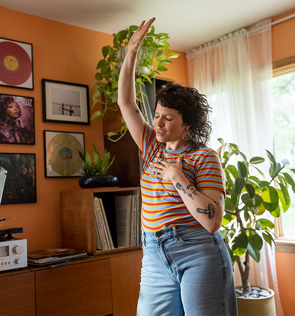 Woman dancing in living room listening to music